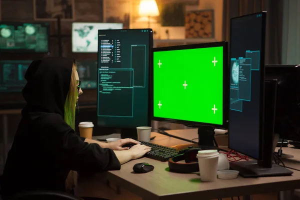 緑の画面でコンピュータ上の女性サイバー犯罪者の入力 — ストック写真