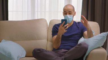 Güvenlik maskeli bir adam görüntülü arama yapıyor.