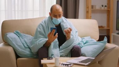 Hekimlik sırasında doktorla görüntülü konuşma yapan hasta bir adam.