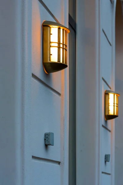 En lysande lampa på väggen i en byggnad — Stockfoto