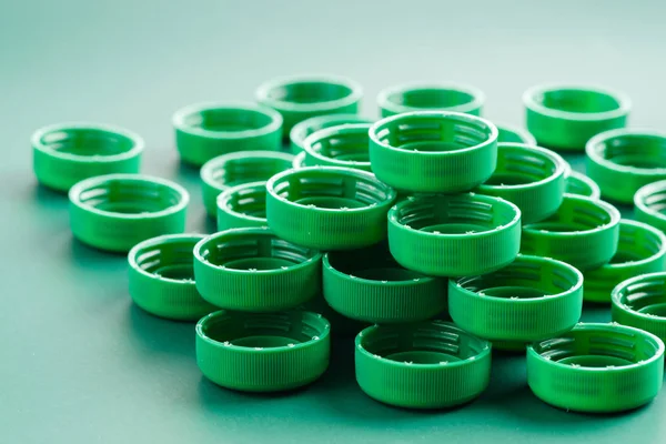 Grüne Plastikverschlüsse aus Flaschen auf der Rückseite — Stockfoto