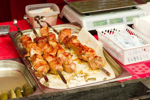 Смажене свиняче м'ясо на шампурах лежить на стійці — стокове фото