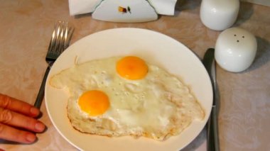 Bir masa örtüsü bir masada duran bir plaka üzerinde pişmiş yumurta hizmet.