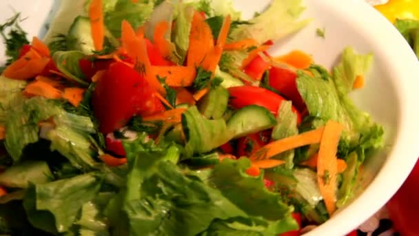 Grönsakssallad i en vit porslinsskål och två paprika — Stockvideo