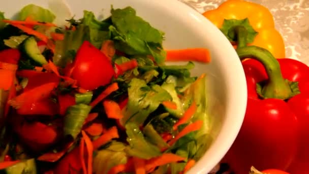 Gemüsesalat in einer weißen Porzellanschüssel und zwei Paprika — Stockvideo