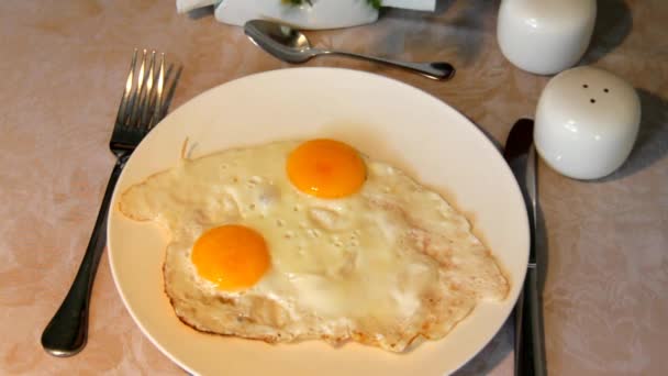 Подача яєць на тарілці, стоячи на столі зі скатертиною . — стокове відео