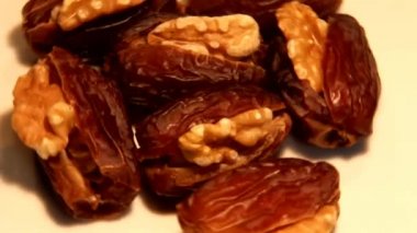 Kağıt arka plan üzerinde kamera önünde dönen ceviz tarihleri dolması