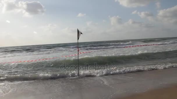 Black Flag και ριγέ κόκκινο λευκή κορδέλα στην παραλία — Αρχείο Βίντεο