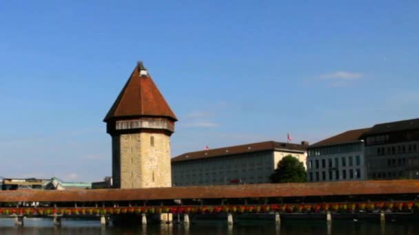 Bord de l'eau de la rivière Reuss Surplombant le célèbre pont de la chapelle en bois et le château d'eau de Luzern, Suisse — Video