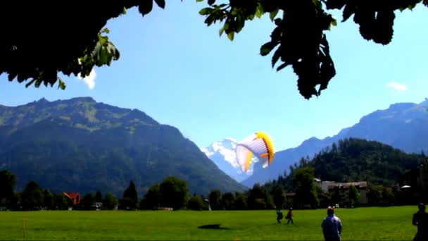 Paraglidisty u Bernských Alp a zasněžený vrchol Jungfrau ve Bernském Oberlandu — Stock video