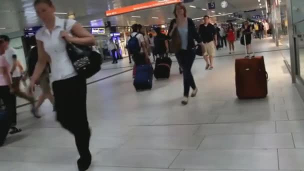 Пассажиры с вещами проходят через подземный вокзал в Дюссельдорфе — стоковое видео