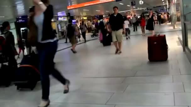 Passagers avec des choses passent par un passage souterrain de la gare de Düsseldorf — Video