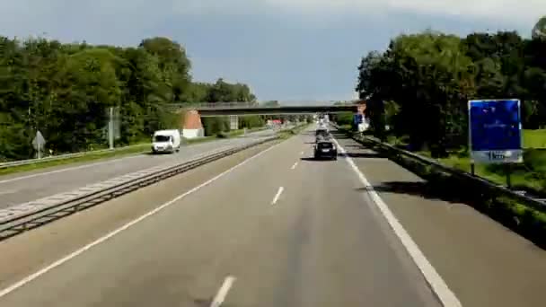 Linienbus auf der Autobahn mit Cloads an einer Grenzmarke zwischen Deutschland und den Niederlanden — Stockvideo