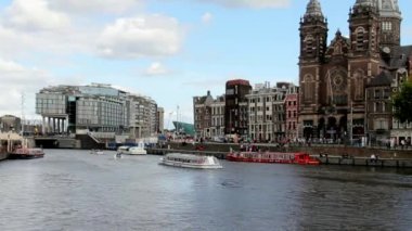 St. Nicholas Kilisesi ve evler üzerinden arasında Amstel Nehri günbatımı ışığı görünümünü. Amsterdam