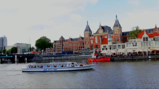Στον ποταμό Amstel στον κεντρικό σιδηροδρομικό σταθμό του φόντου. Άμστερνταμ — Αρχείο Βίντεο
