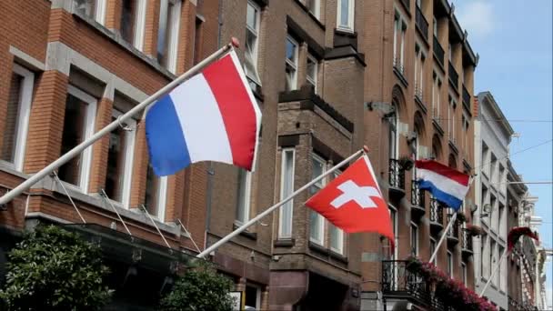 Флаги Нидерландов, Швейцарии и Амстердама на площади Дам в центре Амстердама — стоковое видео