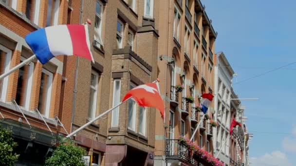 Флаги Нидерландов, Швейцарии и Амстердама на площади Дам в центре Амстердама — стоковое видео