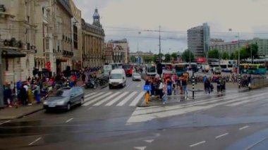 Otobüs de Amsterdam Merkez tren istasyonu yakınında bulutlu yağmurlu yaz gününde sürüş.