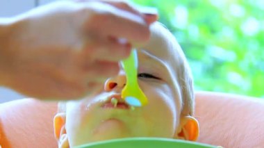 sevimli küçük çocuk kaşık, kapalı ateş kullanarak besleniyor