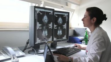 Genç kadın doktor hasta Famale meme kanseri araştırmaları bilgisayardaki sonuçlarını inceler