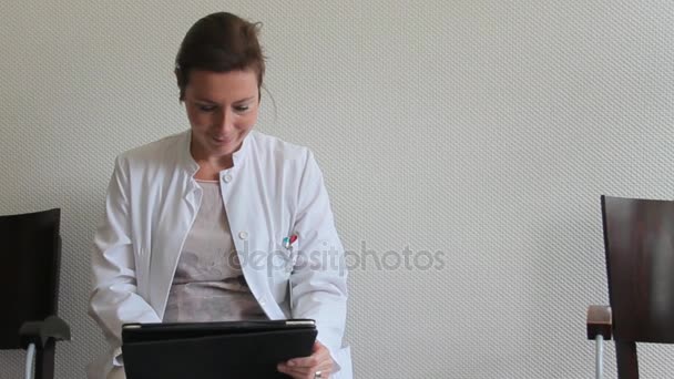 Giovane donna medico che lavora con una tavoletta in sala d'attesa presso l'ospedale — Video Stock