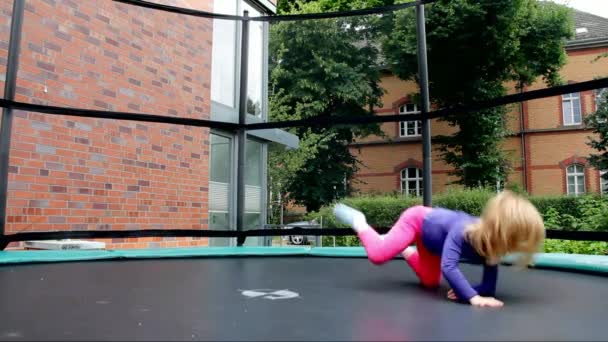 Lilla flickan hoppar på studsmatta på på gården av privat hus — Stockvideo