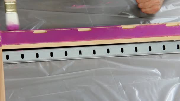 Mão segurando uma escova aplicando tinta de verniz em uma superfície de madeira — Vídeo de Stock