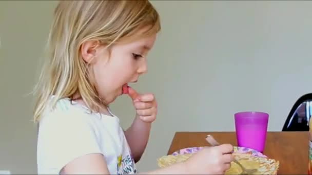Kleines Mädchen isst Pfannkuchen und trinkt zu Hause Milch — Stockvideo