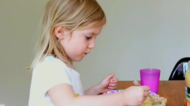 Niña comiendo panqueques y bebiendo leche en casa — Vídeos de Stock