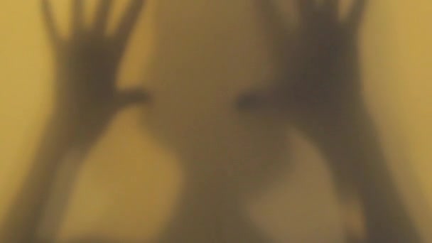 Escena de película de terror con la mano y la cabeza femeninas, y sombras espeluznantes en la ventana de vidrio en la puerta — Vídeos de Stock