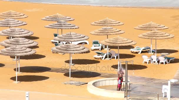 Padre e hijo se duchan en la playa del Mar Muerto después del tratamiento del agua — Vídeos de Stock