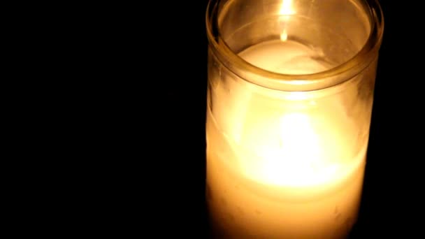 Palącej się świecy w zlewce szklanej na ciemnym tle — Wideo stockowe