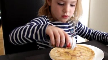 Bir masada oturuyor, Apple Mus veya reçel ve tarçın ile Pancakes yemek çizgili elbiseli küçük kız