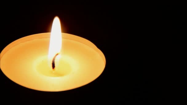 Detailní záběr na hořící svíčka na pozadí tmavě dřevěný stůl — Stock video