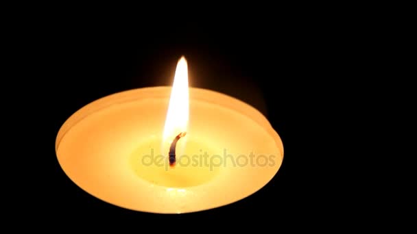 Closeup of Burning Candle no fundo da mesa de madeira escura. Câmara se move para a esquerda — Vídeo de Stock