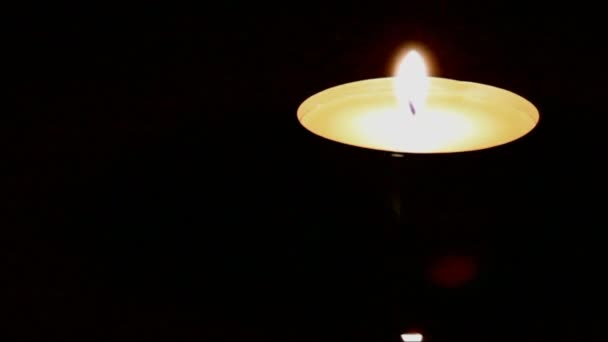 Крупный план свечи на фоне тёмного деревянного стола — стоковое видео