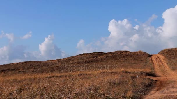 모래도로 떨어져 모래 크로스와 자동 스포츠는 파란 하늘과 흰 구름 배경에 추적 합니다. 카메라 이동 오른쪽 — 비디오