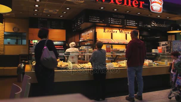 Passageiros perto de um pequeno café em um dos salões no Aeroporto Internacional de Frankfurt — Vídeo de Stock