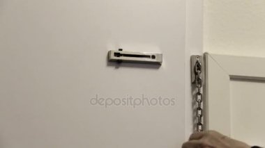 Kapanış güvenlik zinciri bağlı bir iç House kapı için yaşlı kadındır