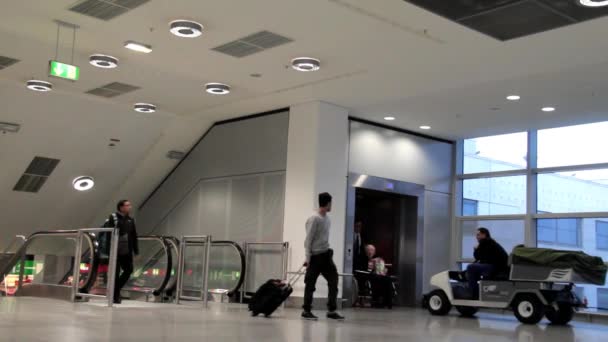 L'employé conduit la personne handicapée dans la poussette à son voyage dans l'une des salles de l'aéroport international — Video