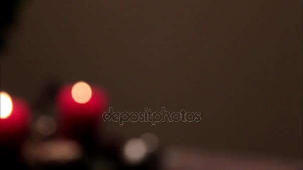Vista borrosa de la instalación de Navidad con velas decorativas rojas ardientes en la mesa — Vídeos de Stock