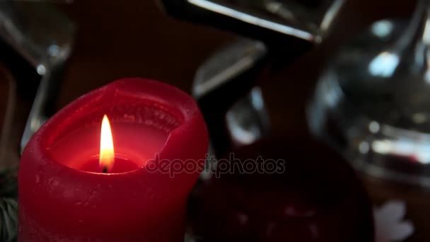 Installazione natalizia con candela decorativa bruciante rossa e ghirlanda di abeti su tavolo di legno marrone — Video Stock