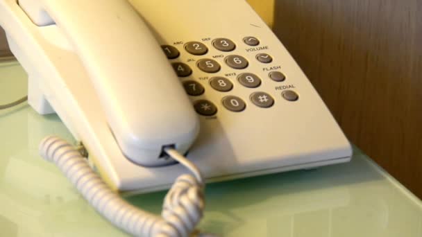 Starší muž ruku vytočí číslo na starém telefonu bílý stůl — Stock video