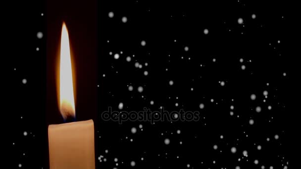 Горящая свеча с эффектом падающего снега на темном фоне — стоковое видео