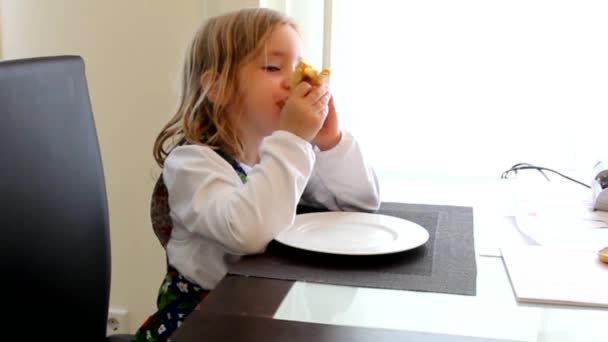 Niña vestida a rayas sentada en una mesa, comiendo panqueques con mousse de manzana o mermelada y canela — Vídeos de Stock