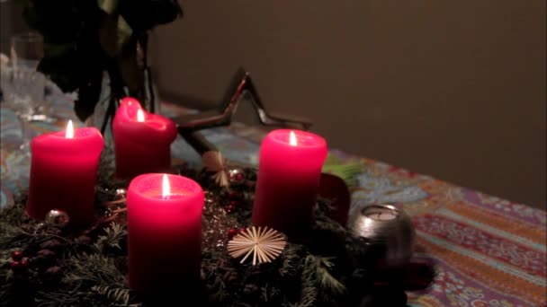 Vista borrosa de la instalación de Navidad con velas decorativas rojas ardientes en la mesa — Vídeo de stock