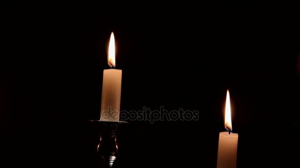 Hořící svíčky v stříbrný svícen na tmavém pozadí — Stock video