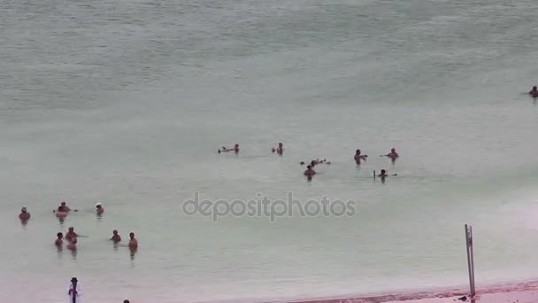 Mensen nemen waterzuivering op dode zee strand. — Stockvideo