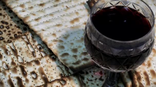 Вид сверху на пасхальное красное вино и Матцо, еврейский праздничный хлеб. Макро — стоковое видео