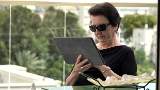 Femme âgée avec tablette sur balcon — Video